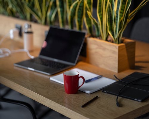 Modern open space office desk with a coffee mug